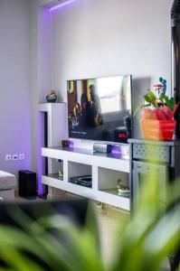 a living room with a tv on a white shelf at MegaLuxe Apartment in Heraklio
