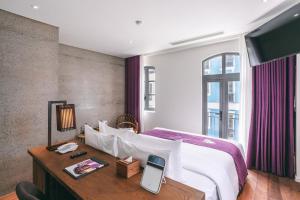 a hotel room with a bed and a desk with a phone at JM Boutique Hotel in Phu Quoc +107 photos