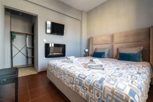 1 dormitorio con 1 cama y TV en la pared en MegaLuxe Apartment, en Heraclión