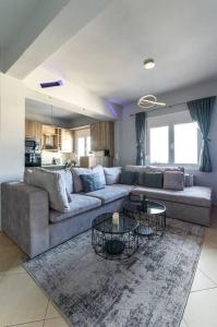 ein Wohnzimmer mit einem Sofa und 2 Tischen in der Unterkunft MegaLuxe Apartment in Iraklio