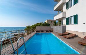 寇齊諾的住宿－Cozy Home In Kozino With Jacuzzi，一座位于一座带海洋的建筑的阳台上的游泳池