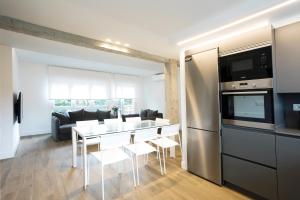 cocina y sala de estar con mesa y electrodomésticos en Akartegi by Basquelidays, en Hondarribia