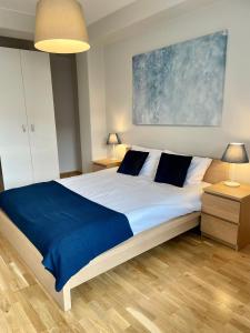 1 dormitorio con 1 cama grande con manta azul en Boutique Apartments - Old Town 120m2 - Private Underground Parking -, en Wroclaw