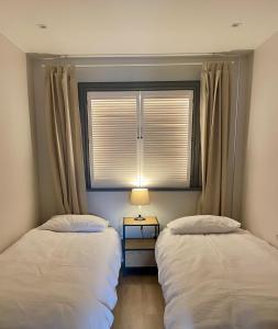 2 camas en una habitación con ventana y lámpara en Boutique Apartments - Old Town 120m2 - Private Underground Parking -, en Wroclaw