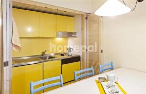 a kitchen with yellow cabinets and a table and chairs at Residence Universo in Pré-Saint-Didier