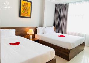 duas camas num quarto com flores vermelhas em Camelia 108 Le Lai Hotel em Ho Chi Minh