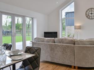 - un salon avec un canapé et une table dans l'établissement Old Byre Cottage - Uk43377, à Kirklinton