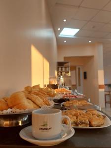 a buffet with plates of pastries and a cup of coffee at Urunday Apart Hotel in Posadas