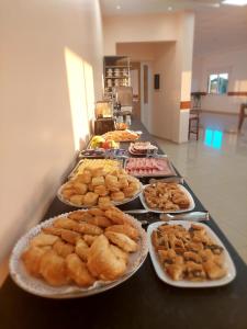um buffet de diferentes tipos de pastelaria em pratos em Urunday Apart Hotel em Posadas