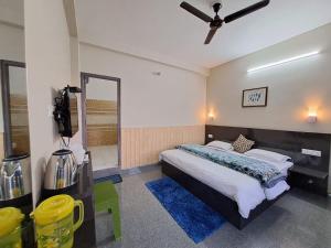 - une chambre avec un grand lit et un tapis bleu dans l'établissement FORTUNE HEIGHTS DALHOUSiE, à Dalhousie