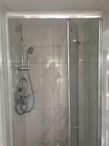 a shower with a glass door in a bathroom at home away from home in Croydon