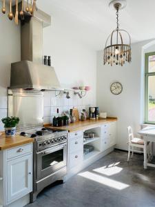 uma cozinha com armários brancos e um forno com placa de fogão em Ferienwohnung im Gästehaus em Meissen