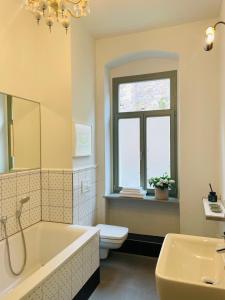 uma casa de banho com uma banheira, um WC e um lavatório. em Ferienwohnung im Gästehaus em Meissen