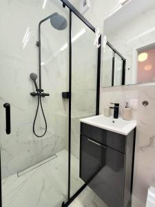 baño blanco con ducha y lavamanos en Apartment Sophie 3 rooms, 2 bathrooms, 8 persons, en Cracovia