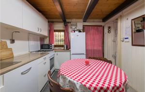kuchnia ze stołem z czerwoną i białą szachownicą w obiekcie 1 Bedroom Cozy Apartment In Premantura w mieście Premantura