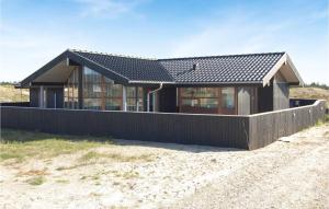 BjerregårdにあるBeautiful Home In Hvide Sande With Saunaの海辺の黒屋根の家