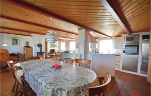 a dining room with a table and a kitchen at 5 Bedroom Stunning Home In ster Assels in Ljørslev