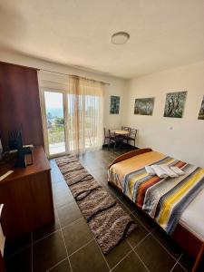 um quarto com uma cama, uma mesa e uma janela em Guest House Djakonovic em Ulcinj