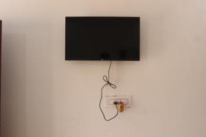 a flat screen tv hanging on a wall at Kopai View in Bolpur