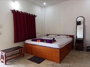 a bedroom with a bed with a red curtain at Kopai View in Bolpur