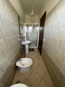 a bathroom with a toilet and a sink at Villa Cilento, PISCINA CAMERE APPARTAMENTI & RISTORANTE in Capaccio-Paestum +46 photos
