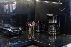 a kitchen counter with a coffee maker and flowers on it at Delis Villa in Kato Gouves +26 photos