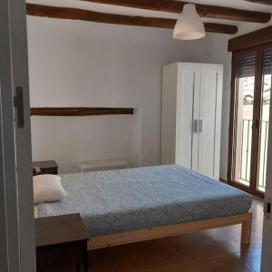 a bedroom with a bed with blue sheets and a window at Casa rural La Azuleja de Alatoz in Alatoz