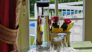 a glass vase sitting on a glass table with flowers at Boutique Hotel Villa am See in Hagnau