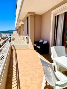 balcón con sillas, mesa y sofá en Spinnaker Holidays, en Alghero