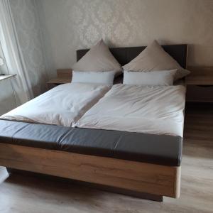 a bed with white sheets and pillows on it at FeWo Altstadt BL in Bad Laasphe