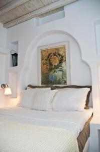 - une chambre avec un lit blanc orné d'une peinture murale dans l'établissement Sea View Exclusive Studios - Tinos, à Agios Ioannis