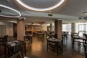 a restaurant with tables and chairs and a large window at Hotel Mediterraneo -Spiaggia Ombrelloni e Lettini Inclusi- in Martinsicuro