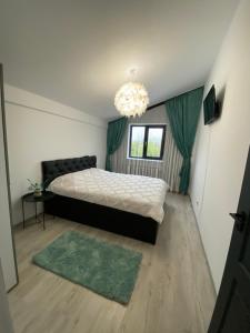 una camera con un grande letto e un lampadario a braccio di Mr&Mrs ApartHotel a Fălticeni