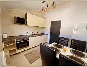 una cucina con tavolo e sedie e una cucina con piano cottura di Mr&Mrs ApartHotel a Fălticeni