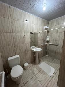 a bathroom with a toilet and a sink at Parada do Parque Hotel in Penha