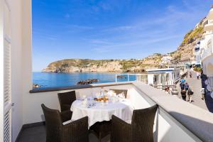 uma mesa numa varanda com vista para o oceano em Roccobarocco Boutique Hotel em Ischia