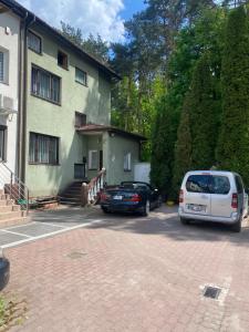dos autos estacionados frente a una casa en Fałata apartament, en Kobyłka