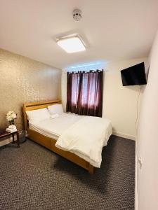 UNIQUE PRIVATE ROOMS في بولتون: غرفة نوم فيها سرير وتلفزيون