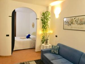 a living room with a blue couch and a bed at La Marina Vernazza Appartamento Piazza Marconi in Vernazza