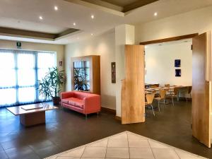 a lobby with a red couch and a table at Hotel Ristorante Trendy in Prato