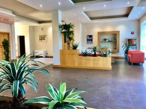 a lobby with potted plants in a building at Hotel Ristorante Trendy in Prato