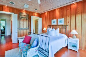a bedroom with a bed and a chair at ROOSEVELT COTTAGE in Captiva