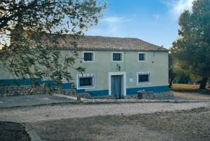 uma casa branca com um acabamento azul em CASAS RURALES LA LAGUNA, ALPERA em Alpera