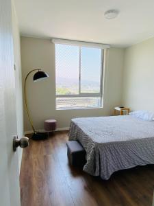 a bedroom with a bed and a large window at Habitación en miraflores in Lima