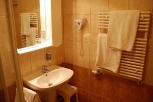 ein Bad mit einem Waschbecken und einem Spiegel in der Unterkunft Hotel Európa Gunaras in Dombóvár