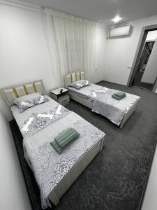 duas camas sentadas num quarto com em ZARA Guest House em Bukhara