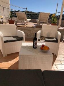 a bottle of wine and a bowl of fruit on a patio at Casa Santa Maria - Suite Mediterraneo in Ponza
