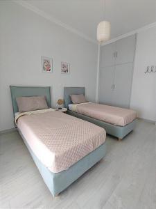 - deux lits dans une chambre blanche avec deux couvre-lits dans l'établissement Deep blue, à Agioi Apostoli