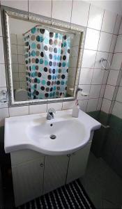 La salle de bains est pourvue d'un lavabo blanc et d'un miroir. dans l'établissement Deep blue, à Agioi Apostoli
