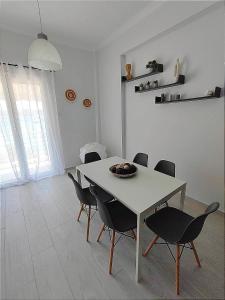 une salle à manger avec une table et des chaises blanches dans l'établissement Deep blue, à Agioi Apostoli
